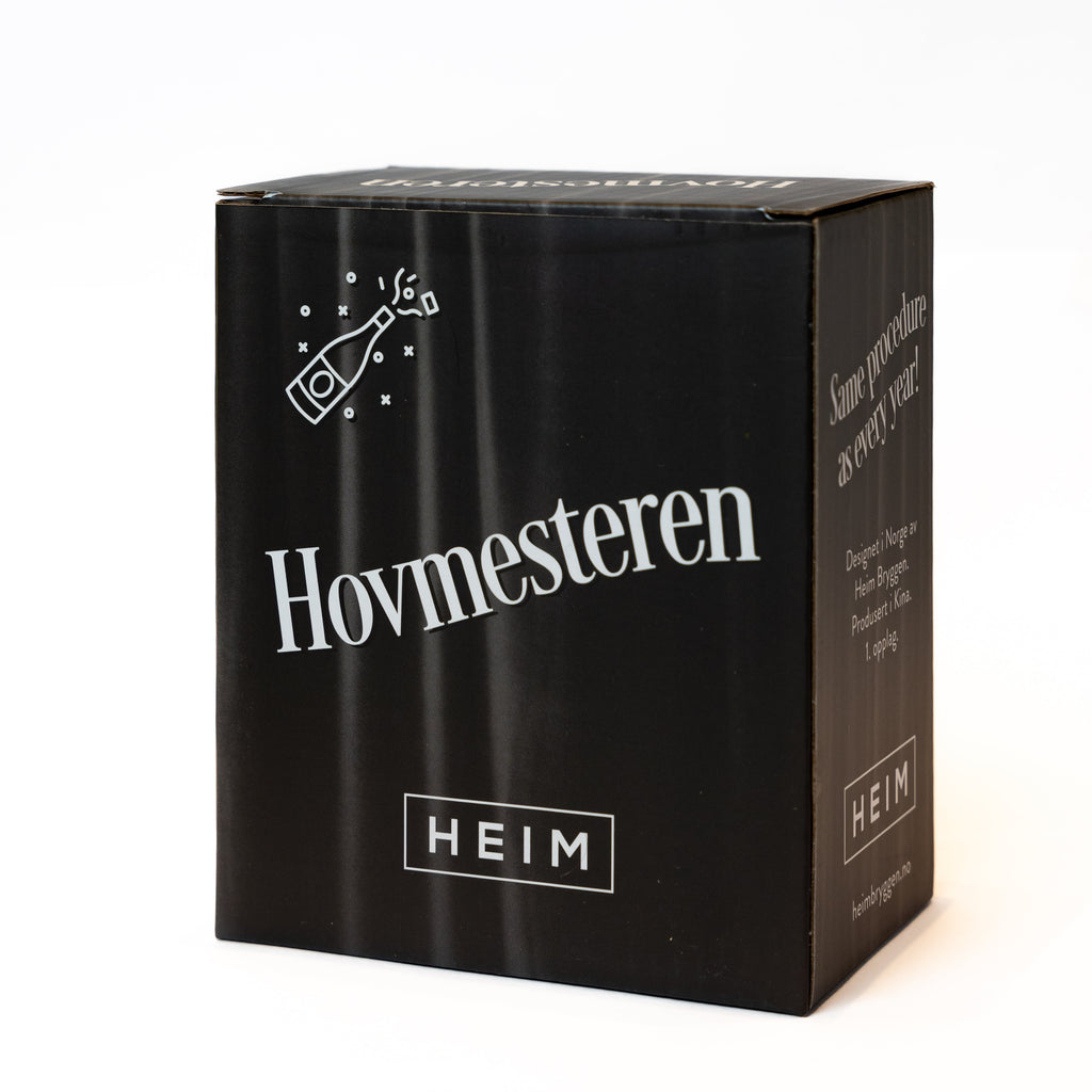GREVINNEN OG HOVMESTEREN Julekuler - By HEIM Studio i svart gaveeske med hvit tekst og illustrasjon av champagneflaske