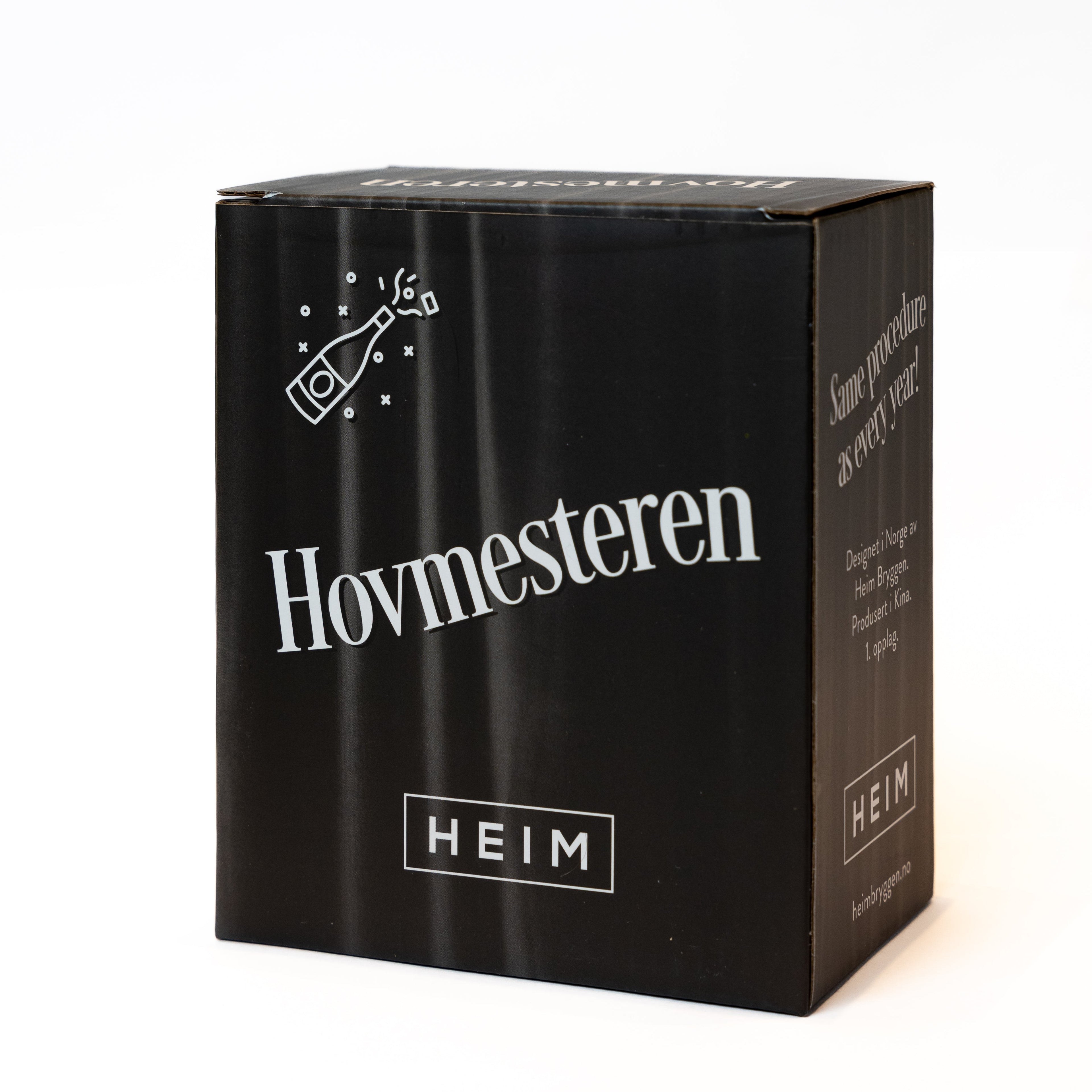 GREVINNEN OG HOVMESTEREN Julekuler - By HEIM Studio i svart gaveeske med hvit tekst og illustrasjon av champagneflaske